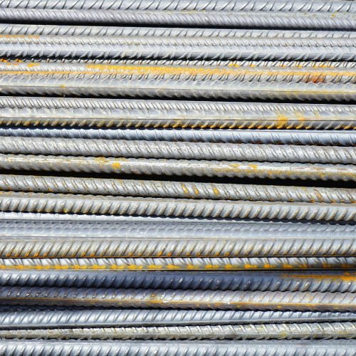 Close-up of stacked rusty steel reinforcing bars used in construction.
